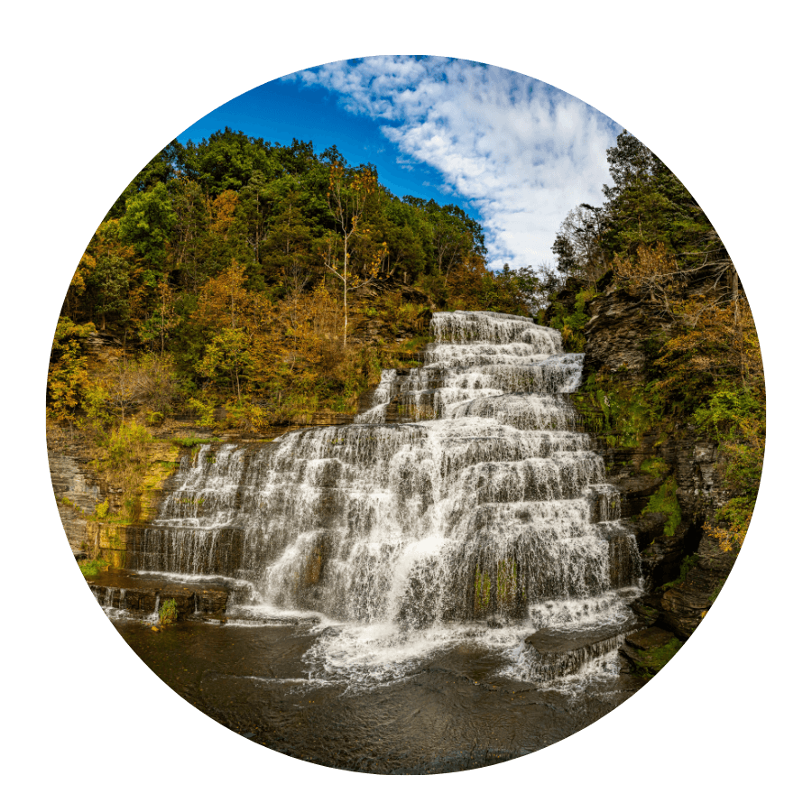 A cascading waterfall surrounded by colorful autumn foliage.