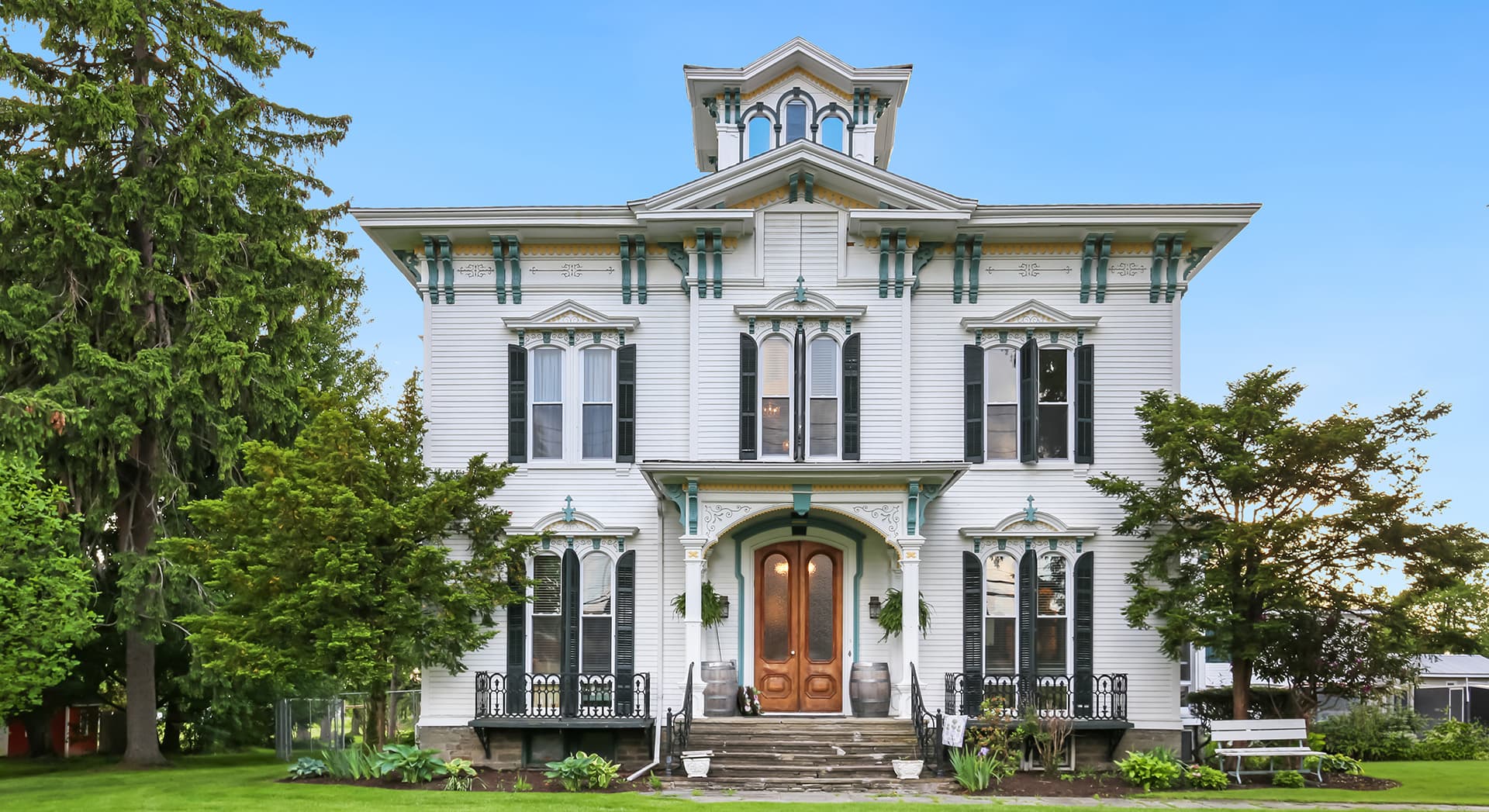 Victorian-style house with ornate trim and a landscaped yard.