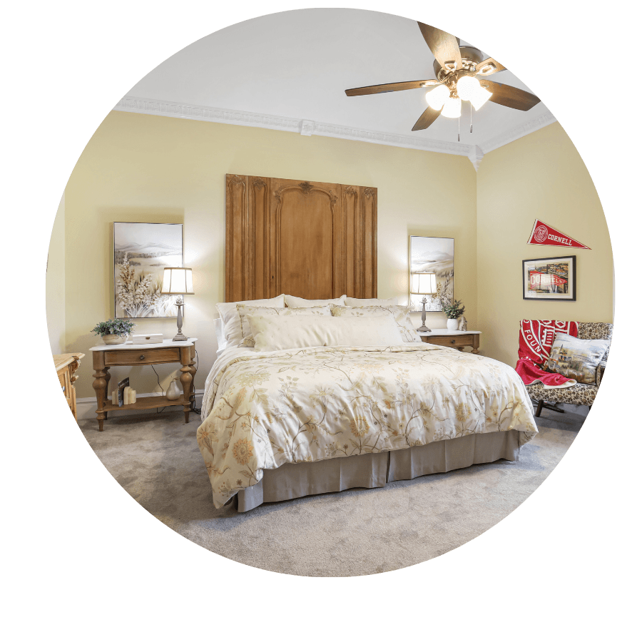Cozy bedroom featuring a large bed, bedside tables, and warm yellow walls.